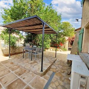 un patio con mesa y sillas bajo un techo en Appartement de 2 chambres avec jardin clos et wifi a Vias a 2 km de la plage en Vias