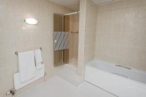 胡克贝辛斯托克Spa酒店的带浴缸和淋浴的白色浴室