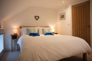 a bedroom with a large white bed with blue pillows at Anroach Farm Peak District in Buxton +29 photos
