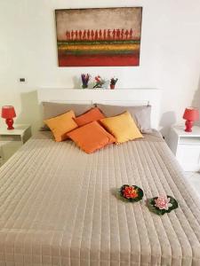 - un lit avec des oreillers orange et un tableau mural dans l'établissement One bedroom apartement with wifi at Palermo, à Palerme