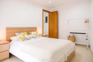 a white bedroom with a large white bed with pillows at Ca lEudald 2 Ideal para parejas con terraza in Besalú
