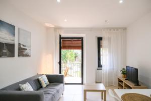 een woonkamer met een bank en een tv bij Ca lEudald 2 Ideal para parejas con terraza in Besalú