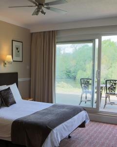 a hotel room with a bed and a large window at Inn On The Lake in Gravesend