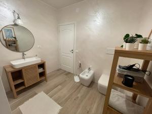 a bathroom with a sink and a toilet and a mirror at All'ombra del tiglio Bed&Breakfast in Doberdò del Lago +14 photos