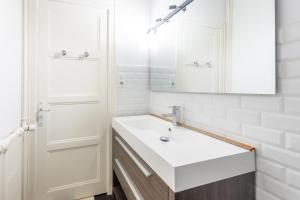 een witte badkamer met een wastafel en een spiegel bij Pretty 2 rooms in the city center in Annecy