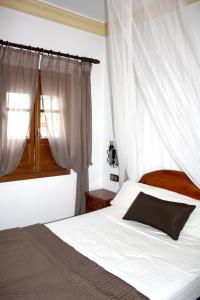 ベナマオマにあるEl Miradorのベッドルーム1室(白いカーテンと窓付)