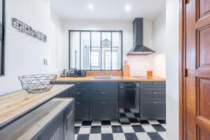 een keuken met zwarte kasten en een geruite vloer bij Pretty 2 rooms in the city center in Annecy