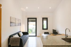 sala de estar con sofá y cocina en Ca lEudald 3 Apartamento en Besalú con terraza en Besalú