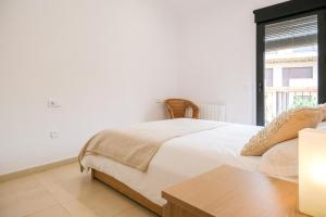 a white bedroom with a bed and a window at Ca lEudald 3 Apartamento en Besalú con terraza in Besalú