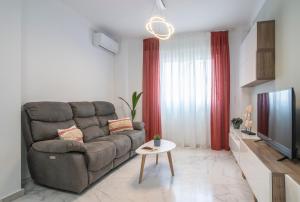a living room with a couch and a television at Los Áticos in Estepona