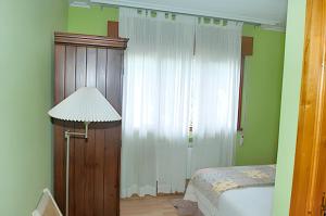 sypialnia z łóżkiem i białą zasłoną w obiekcie One bedroom apartement with shared pool enclosed garden and wifi at San Antolin de Ibias w mieście San Antolín