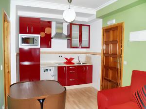 uma cozinha com armários vermelhos e um sofá vermelho em One bedroom apartement with shared pool enclosed garden and wifi at San Antolin de Ibias em San Antolín