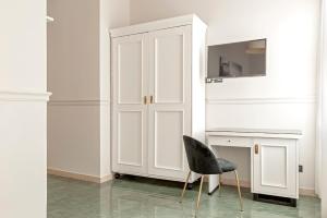 a black chair sitting next to a white cabinet at The Port Residence in Livorno