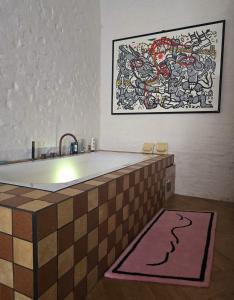 a bathroom with a bath tub with a painting on the wall at stijlvol appartement centrum oostende in Ostend