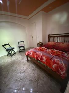 1 dormitorio con 1 cama y 2 sillas en Los gringos del caribe en Saquarema