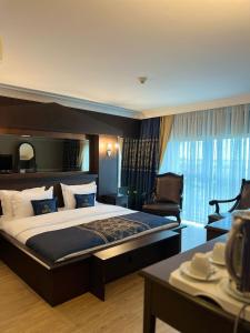 a bedroom with a large bed and a chair at BM HOTEL City in Samsun