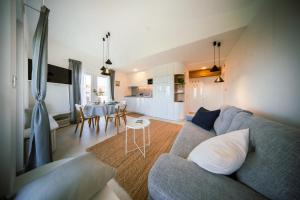 a living room with a blue couch and a kitchen at la belavista in Izola