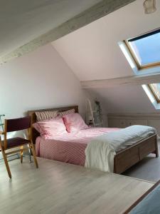 a bedroom with a bed with pink sheets and a window at Propriete d'une chambre avec vue sur la ville et wifi a Neauphle le Chateau in Neauphle-le-Château