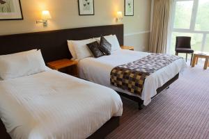 ein Hotelzimmer mit 2 Betten und einem Fenster in der Unterkunft Inn On The Lake in Gravesend