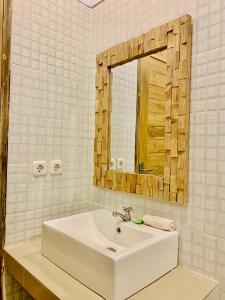 a white bathroom with a sink and a mirror at Bali intan Canggu in Canggu