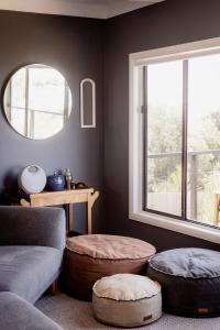 a living room with a couch and a window at 'Lazy Susan's' Waterfront Shack in Primrose Sands