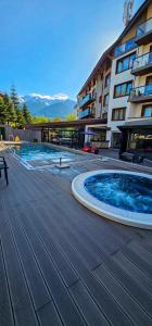 a large swimming pool in front of a building at Studio with balcony, mountain view, 4* SPA Resort, Bansko in Bansko