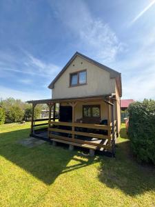 a house with a porch on a grass field at Kopalino 7th Heaven in Kopalino