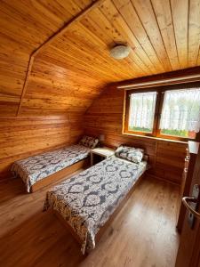 a bedroom with two beds in a wooden cabin at Kopalino 7th Heaven in Kopalino