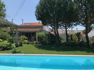 a house with a swimming pool in front of a yard at Casa Oliva - Casa da Mata in Porto de Mós
