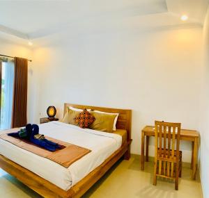 a bedroom with a bed and a table and a chair at Bali intan Canggu in Canggu