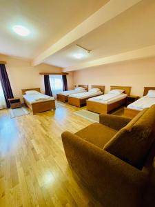 a large room with several beds and a couch at Rákóczi Center in Odorheiu Secuiesc +23 photos