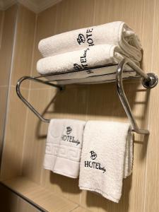 BM HOTEL City في سامسون: مجموعة من المناشف على رف المناشف في الحمام