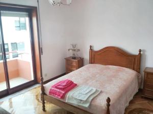 ein Schlafzimmer mit einem Bett mit zwei Handtüchern darauf in der Unterkunft 2 bedrooms apartement at Espinho 600 m away from the beach with furnished terrace in Espinho