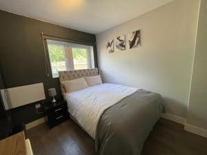 a small bedroom with a bed and a window at Letzi Private En-Suite Near Wembley in London