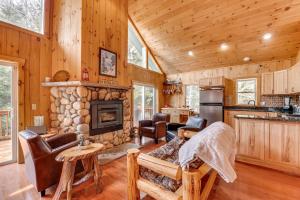 a kitchen and living room with a stone fireplace at Tranquil Thornton Cabin Deck, Views and Game Room! in Thornton