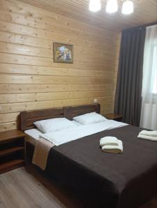 una camera da letto con un letto e due asciugamani di U Anastasii i Sofii bilya richki a Mykulychyn