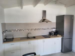 a kitchen with white cabinets and a stainless steel refrigerator at Preciosa cabaña in Guía de Isora