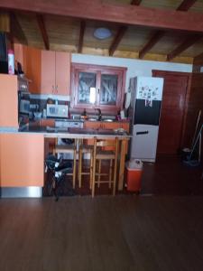 cocina con mesa y nevera en casa vacacional, en Ledaña