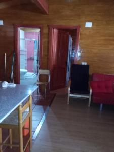 sala de estar con sofá rojo y silla roja en casa vacacional, en Ledaña