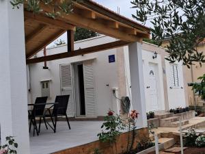 a patio with chairs and a table in a house at Kuća za odmor Neva in Nečujam