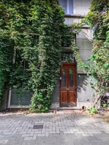 a house with a wooden door with ivy growing on it at La bellétage by Agelandkaai be with Parking in Ghent