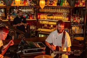 a man playing a guitar in a bar at Skeffington Arms Hotel in Galway