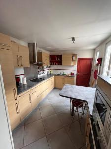 a kitchen with wooden cabinets and a table in it at Magnifique maison toulousaine in Toulouse