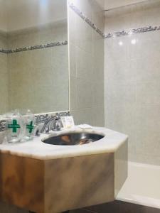y baño con lavabo y espejo. en Astoria Hotel en Buenos Aires