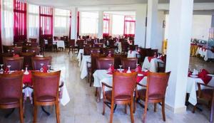a dining room with tables and chairs with red bows at Hotel Angle Atlas in El Ksiba