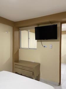 een slaapkamer met een flatscreen-tv aan de muur bij Cabañas covemar in Coveñas