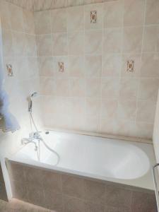 uma banheira branca numa casa de banho com azulejos em Appartement d'une chambre avec jardin a Bolquere a 3 km des pistes em Bolquère - Pyrénées 2000