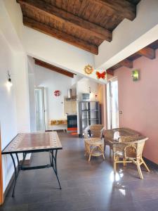 uma sala de estar com mesas e cadeiras e uma cozinha em 2 bedrooms apartement with furnished balcony and wifi at Casalvecchio Siculo 6 km away from the beach em Casalvecchio Siculo