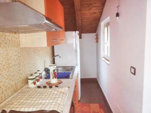 uma pequena cozinha com um lavatório e um frigorífico em 2 bedrooms apartement with furnished balcony and wifi at Casalvecchio Siculo 6 km away from the beach em Casalvecchio Siculo