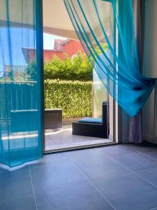 uma porta de vidro deslizante aberta com uma cortina azul em Studio Jardin Fleuris Parking em Nice